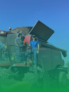 Okuni Africa engineer standing on a large agricultural combine harvester.